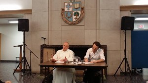 Jacques Dupont, a Carthusian Monk, sits and speaks while another man takes notes.